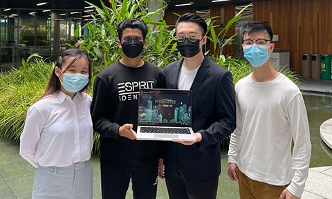 Photo with a group of 4 students, 1 female and 3 male. 2 male students at the center are holding a laptop.