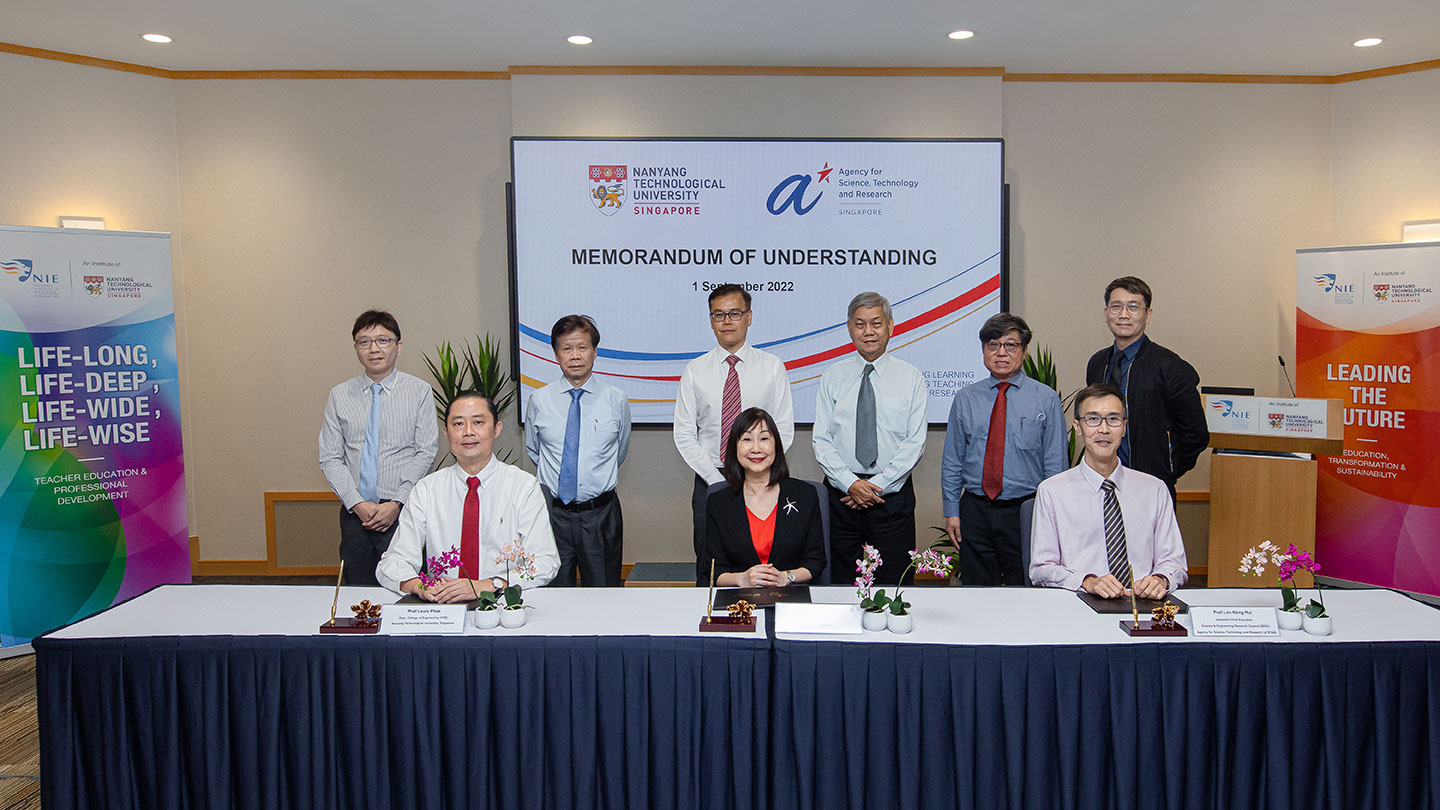 Group photo of 9 peoples in a MoU signing ceremony.