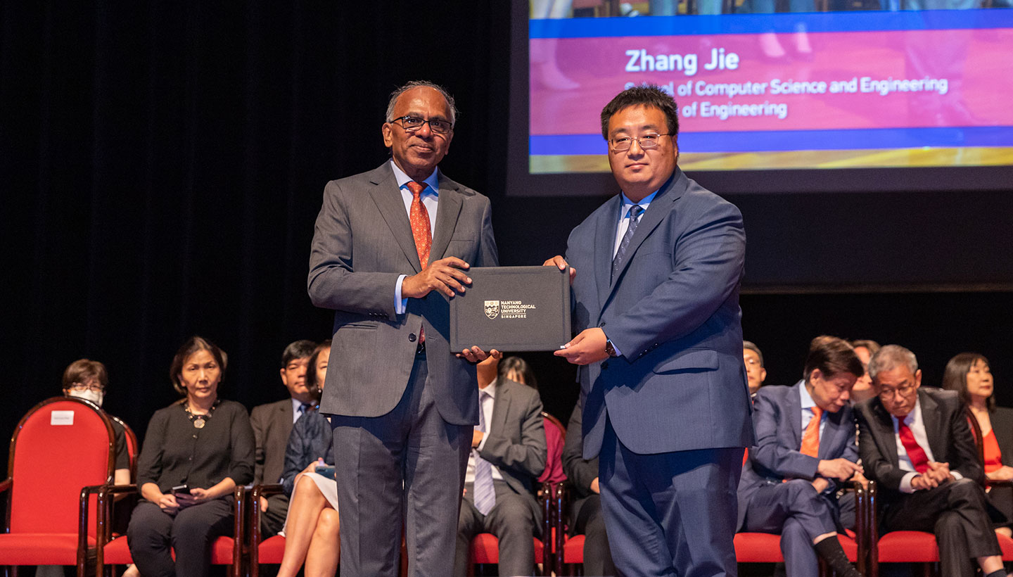 Photo of Professor receiving certificate from NTU President on stage.