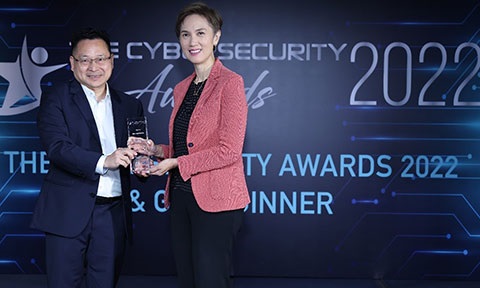 Photo of a professor receiving an acrylic plaque from a minister.