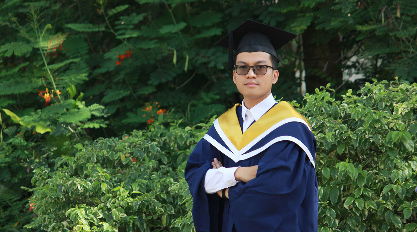 Photo of an undergraduate in convocation gown and cap.