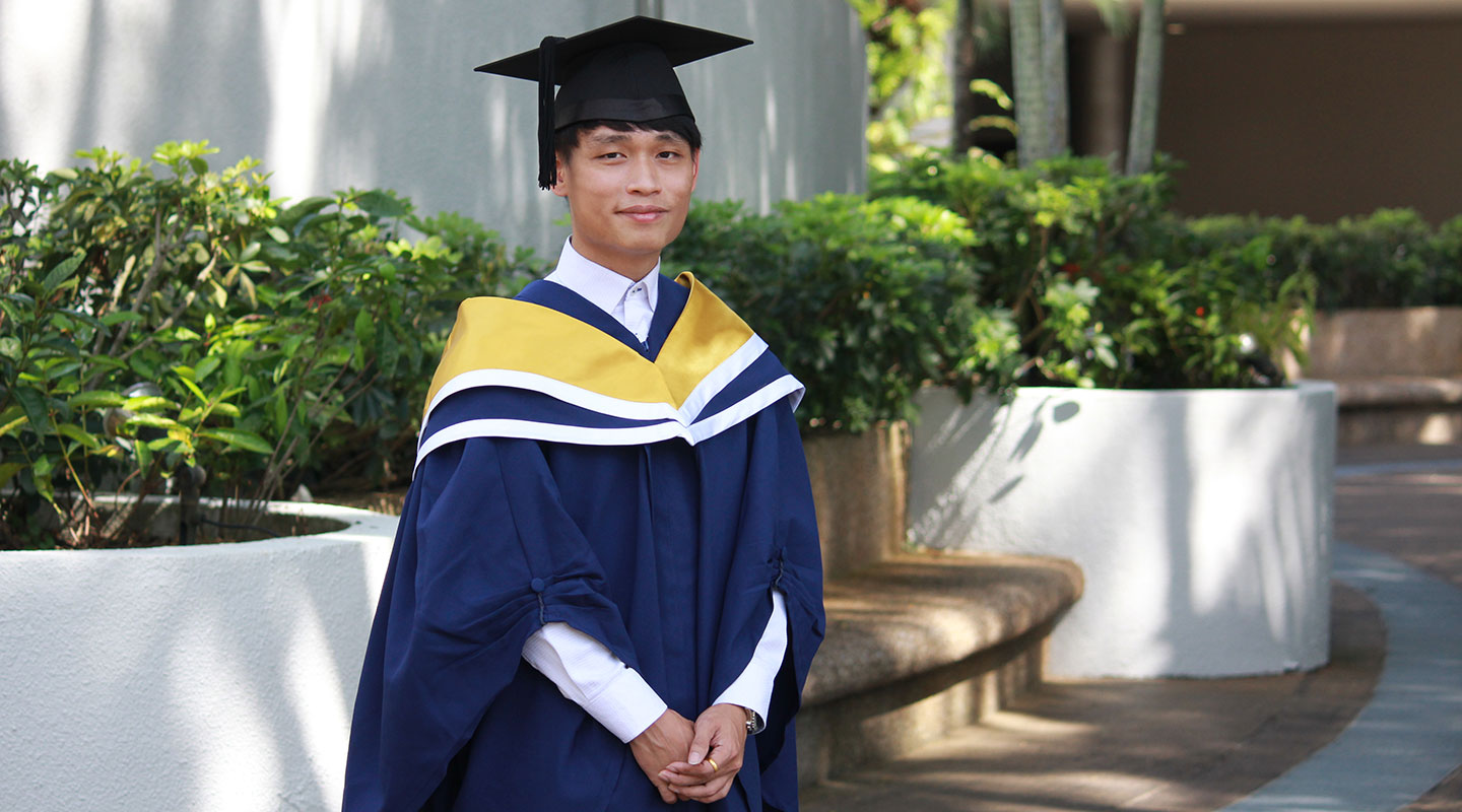 Photo of an undergraduate in convocation gown and cap.