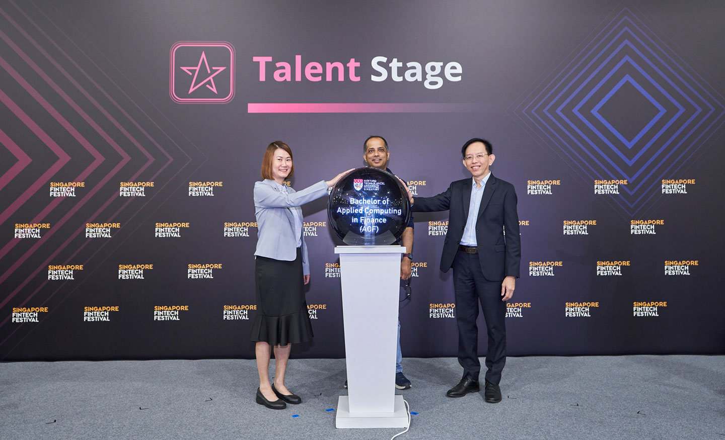 Photo of two Profs launching new UG programme on stage with an officer standing in-between them. 