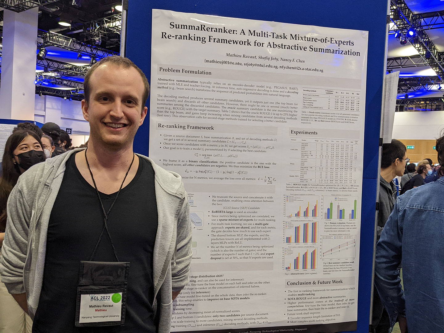 Photo of a postgraduate student standing beside a poster of his project.