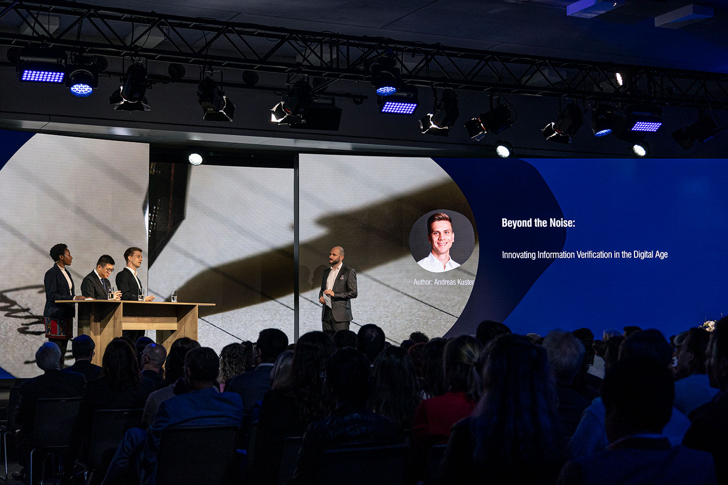 Photo of 3 finalists on stage at the 53rd St. Gallen Symposium 2024