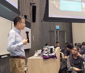 Photo of CCDS Dean, Prof Luke Ong giving a speech to a groups of JC students.
