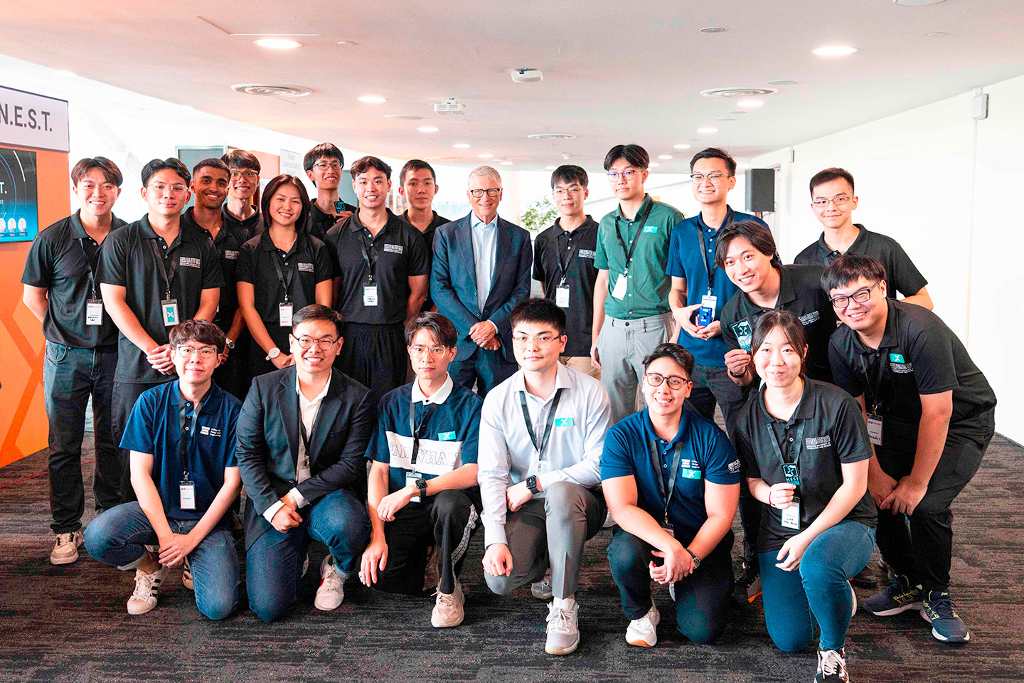 Mr Bill Gates is taking photo with a group of university student from NTU, NUS and SUTD.