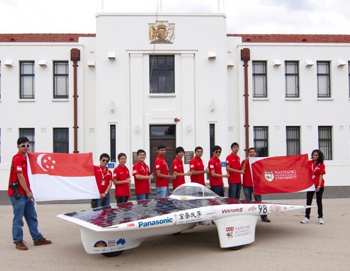Nanyang Venture V team photo holding Singapore flag and NTU flag