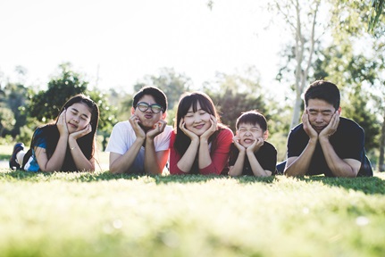 asian family prone on grass