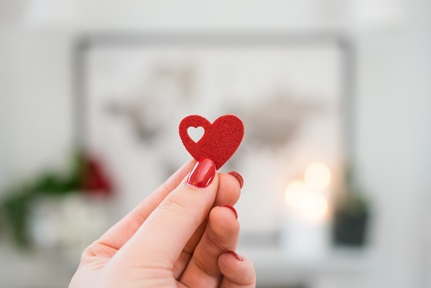 person holding up a cut-out heart