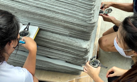 Students using compasses to perform "Strike and Dip" on a 3D printed rock model