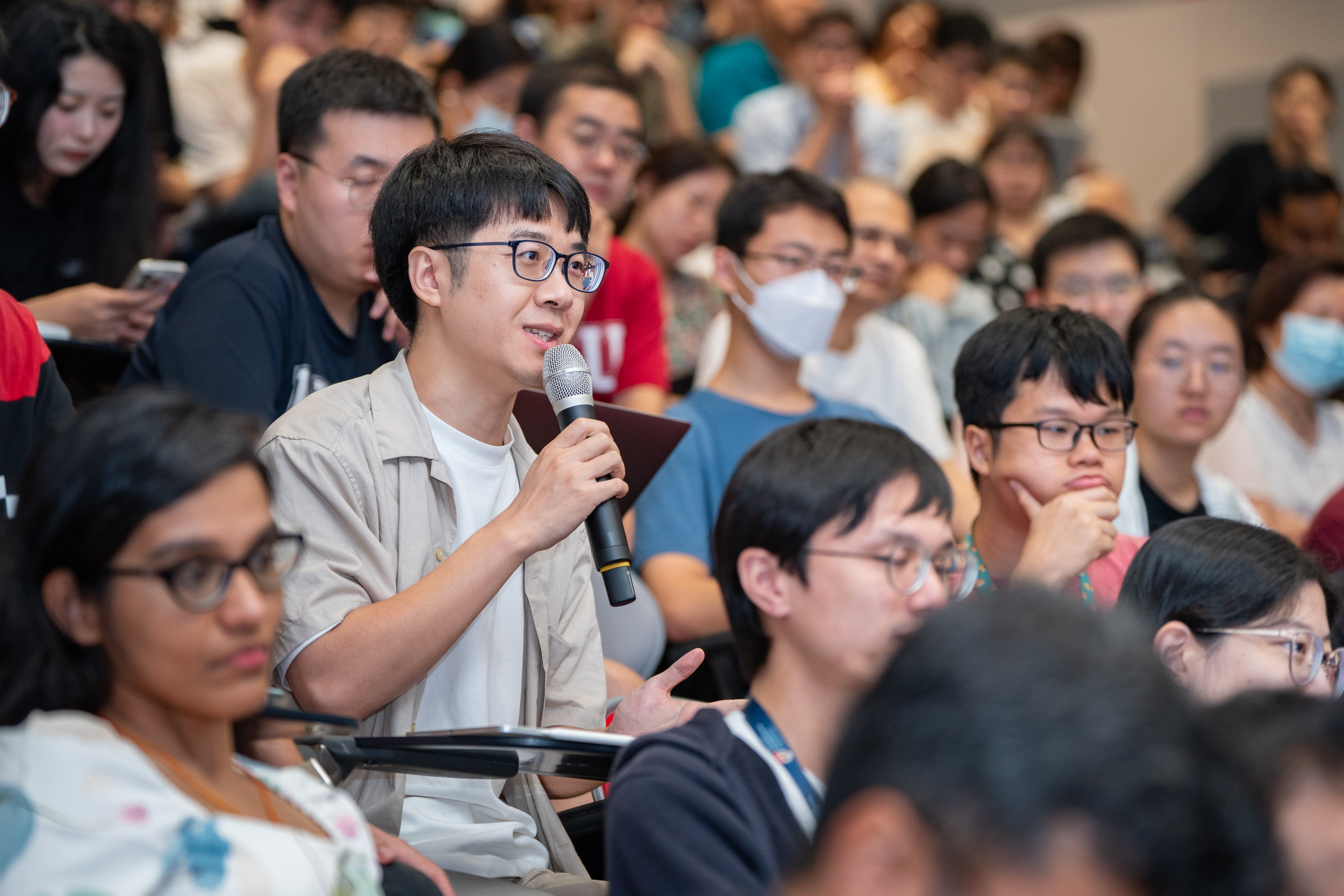Student speaking into microphone in lecture hall