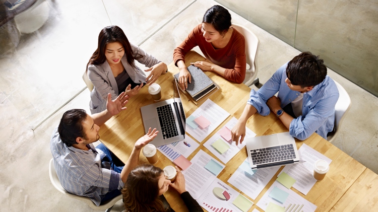 Group of students having coffee and going through a presentation