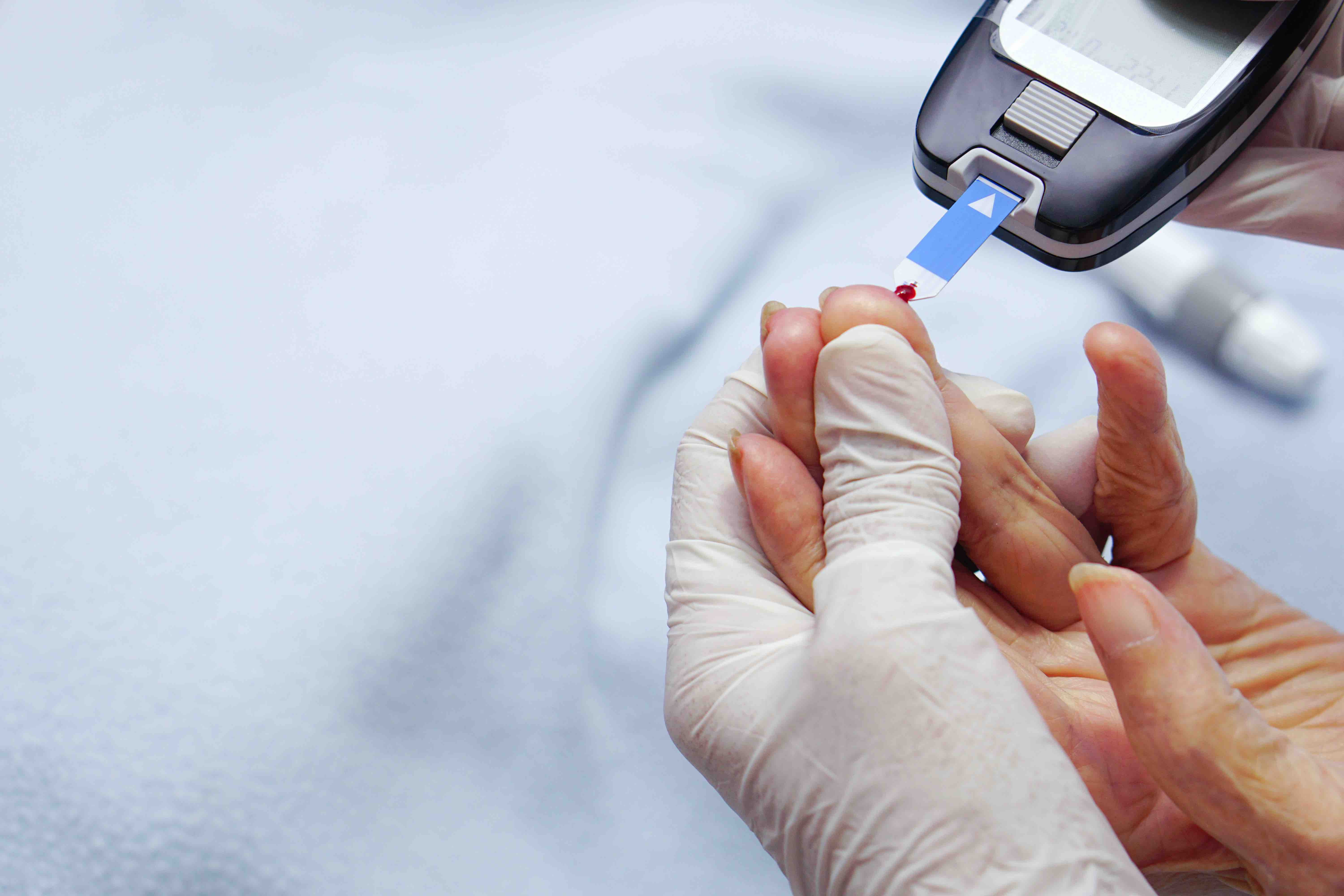 doctor-wear-gloves-using-lancet-finger-checking-blood-sugar-level-by-glucose-meter