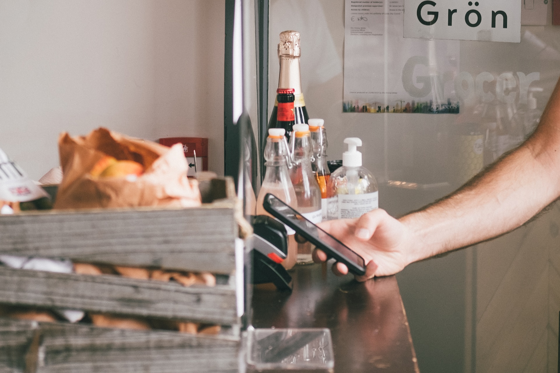 Person making contactless payment via a phone at a cafe