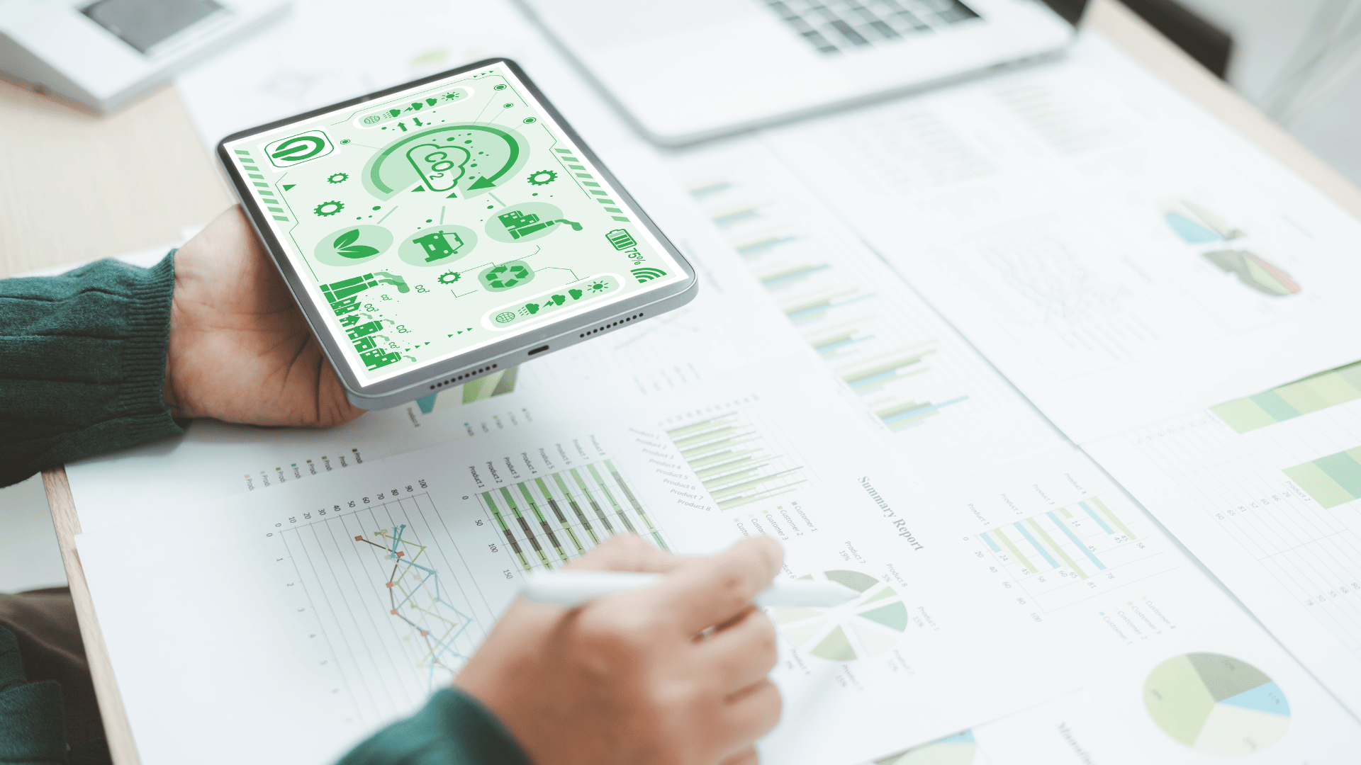 Business person analysing eco data on tablet showing green technology icons
