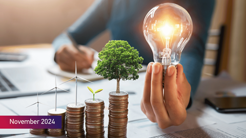Stacks of coins with small plants and wind turbines beside hands with the text November 2024 on bottom left of image