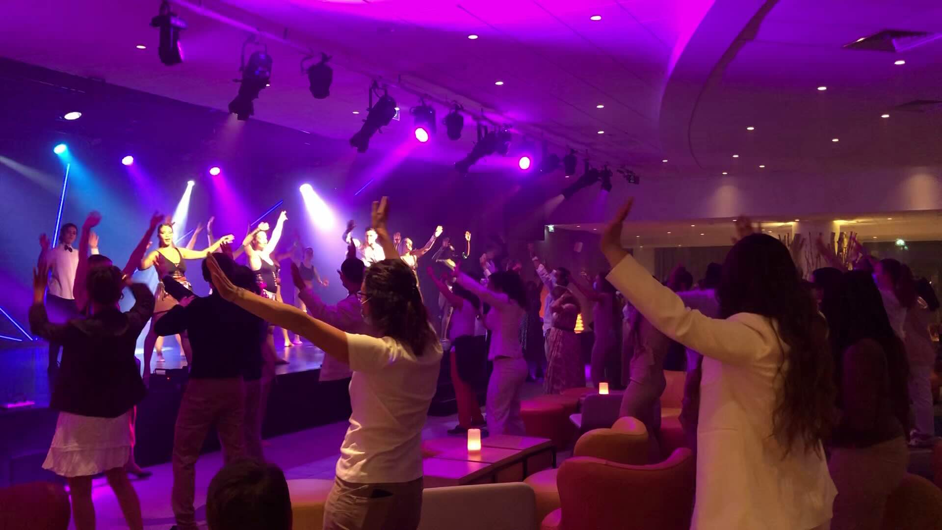 Group of people dancing with performers on stage