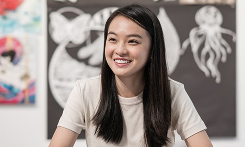 Smiling Chinese Girl with Art in the Background (720x432px)